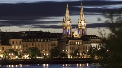 Die beleuchtete Saint-Louis-des-Chartrons Kirche spiegelt sich im Wasser.