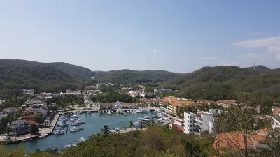 Hafen von Bahia Santa Cruz mit vielen Booten und umgebenden Hügeln.