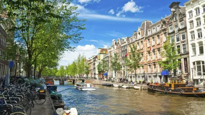 Typische Amsterdamer Kanalszene mit Häusern und Fahrrädern.