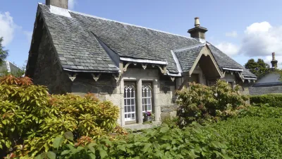 Gemauerte Hütte mit blühenden Pflanzen im Garten