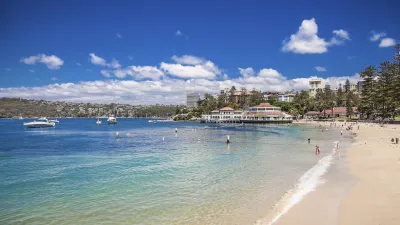 Strandbesucher genießen einen sonnigen Tag am Manly Beach.