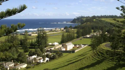 Historische Häuser und grüne Hügel an der Küste der Norfolkinsel.