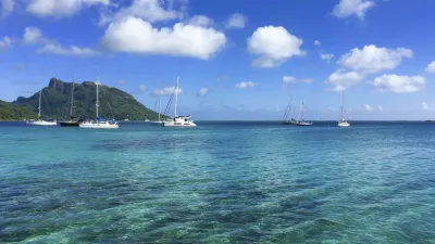 Katamarane ankern in der ruhigen Lagune von Huahine
