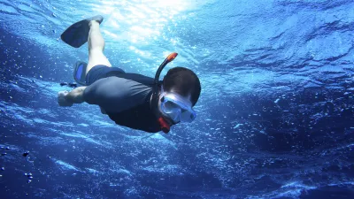 Taucher schnorchelt im blauen Meer