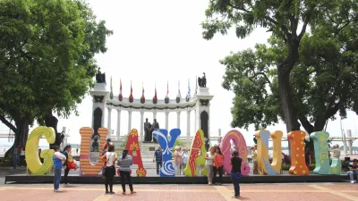 Menschen fotografieren die farbenfrohen Buchstaben des Schriftzugs "Guayaquil".