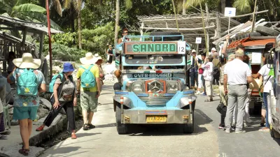 Ein blauer Bus steht auf einer Straße, umgeben von Fußgängern.