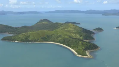 Grüne Insel mit Sandstrand im türkisfarbenen Meer