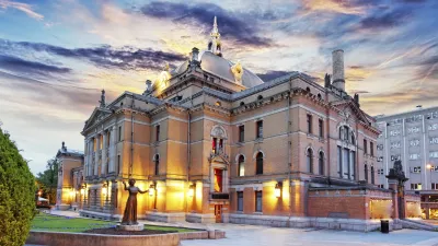 Das Nationaltheater in Oslo leuchtet im Abendlicht.