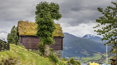 Traditionelle norwegische Holzhütte mit Grasdach in malerischer Landschaft