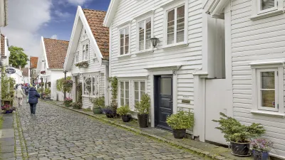 Historische Fachwerkhäuser säumen eine gepflasterte Gasse in Stavanger