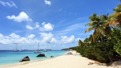 Karibischer Strand mit türkisfarbenem Wasser und Palmen.