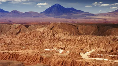 Rote Felsen und Dünen prägen die trockene Landschaft der Atacama-Wüste in Chile.