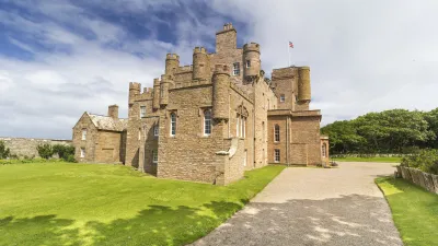 Historisches Schloss von Mey mit gepflegtem Rasen und Kiesweg.