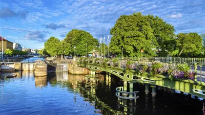 Grüne Brücke über einen Kanal in Göteborg mit blühenden Blumenkästen.