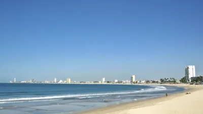 Goldener Sandstrand mit Blick auf das blaue Meer und die Skyline von Mazatlan.