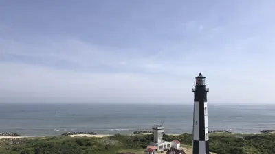Der schwarz-weiße Leuchtturm steht an der Küste mit Blick auf das Meer.