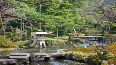 Japanischer Garten mit Steinlaterne und Flusslauf.