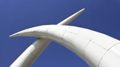 Elefantenstoßzähne aus Metall ragen in den blauen Himmel.