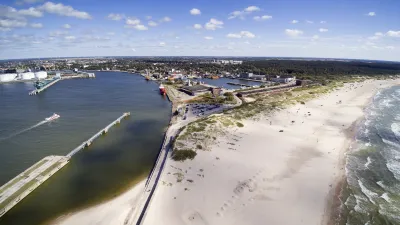 Lettlands Hafenstadt Ventspils zeigt eine Küstenansicht mit Strand und Mole.