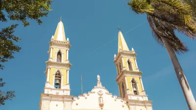 Historische Kirche mit zwei hohen Türmen an einem sonnigen Tag.