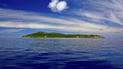 Tropische Insel mit üppiger Vegetation im tiefblauen Meer.