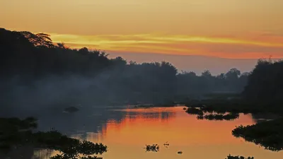Sonnenuntergang über dem Tonle Sap Fluss mit Spiegelung im Wasser