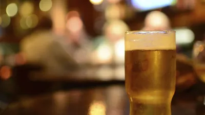 Ein Glas frisches Bier steht im Fokus.