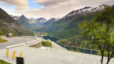 Atemberaubende Aussicht auf den Geirangerfjord mit Bergen und kurviger Straße.