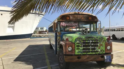 Bunter, restaurierter Oldtimer-Bus steht auf einem Parkplatz.