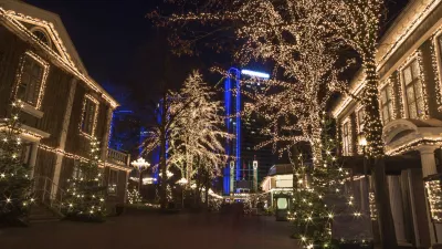 Weihnachtlich dekorierter Vergnügungspark bei Nacht mit beleuchteten Bäumen.