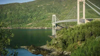 Die Skjomen-Brücke überspannt einen norwegischen Fjord mit grüner Landschaft.