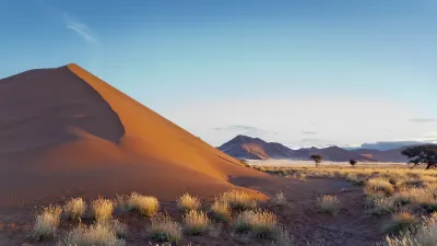 Rote Dünenlandschaft im Namib-Naukluft-Park mit spärlicher Vegetation.