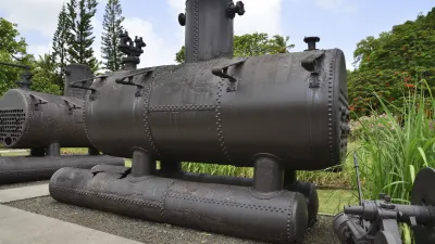 Historische Dampfmaschine steht im Freien auf einer grünen Wiese.