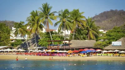 Strand mit Palmen und Menschen in Huatulco, Mexiko