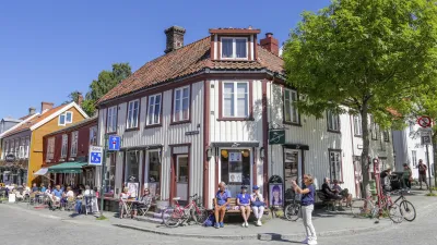 Historisches Holzgebäude mit Menschen in einer belebten Fußgängerzone