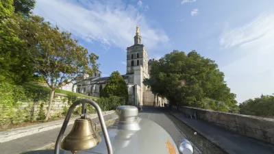 Historische Bimmelbahn fährt an mittelalterlicher Burg in Avignon vorbei