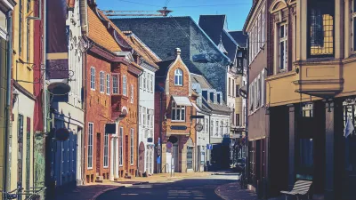 Historische Gebäude säumen die gepflasterte Straße in Odense.