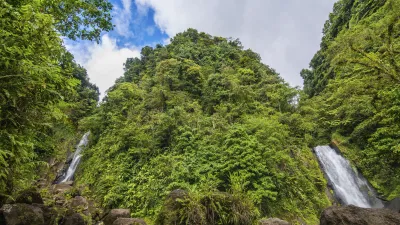 Zwei Wasserfälle stürzen inmitten üppiger grüner Vegetation herab.