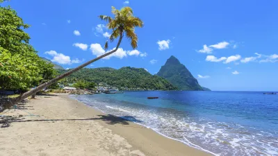 Tropischer Strand mit Blick auf grüne Hügel und blaues Meer