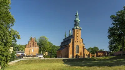 Historische Stiftskirche Kartuzy mit markanten Türmen und roter Backsteinfassade.