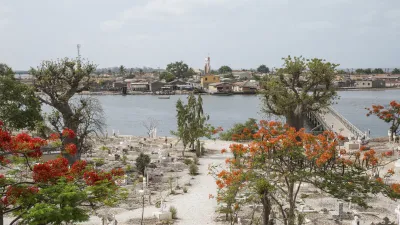 Friedhof mit bunten Bäumen und Blick auf das Meer und die Häuser.