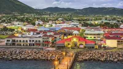 Bunte Gebäude säumen den Hafen von Basseterre bei Nacht.