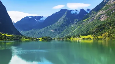 Grüner See zwischen hohen Bergen in Norwegen