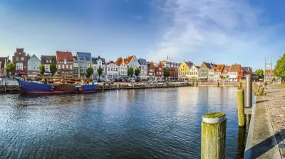 Bunte Häuser säumen das Ufer einer Stadt am Wasser.