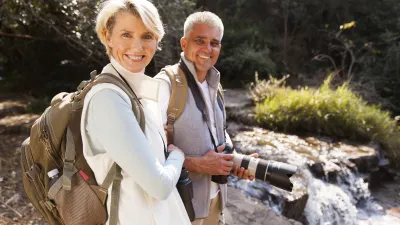 Wanderndes Paar mit Kamera genießt die Natur am Fluss.