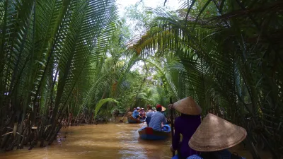 Boote fahren durch den grünen Dschungel des Mekongdeltas