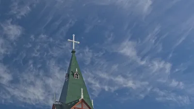 Weiße Kirche mit rotem Zierwerk und grünem Dach in Husavik, Island