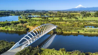 Die moderne Te Rewa Rewa Brücke überspannt einen Fluss vor dem Berg Taranaki.