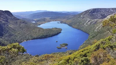 Blauer See in einer Berglandschaft mit üppiger Vegetation.