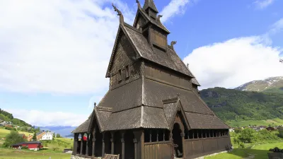 Historische Stabkirche Hopperstad steht inmitten einer grünen Landschaft.